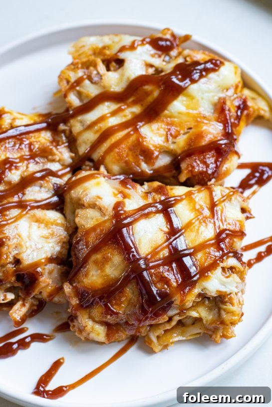 A close-up of a generously topped Sheet Pan BBQ Chicken Pizza with crispy bacon, onions, and melted cheese, making it simple to make for any meal.