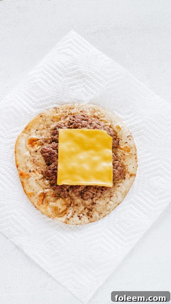 Topping the ground beef or ground turkey for the Big Mac Tacos recipe with a slice of American cheese, ready to melt.