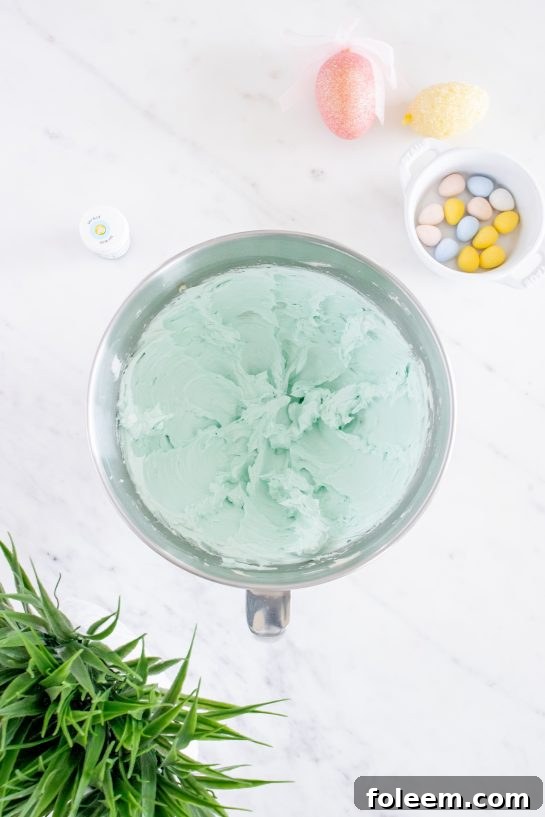 Preparing the vibrant blue frosting for the Easter Speckled Egg Snack Cake in a stand mixer