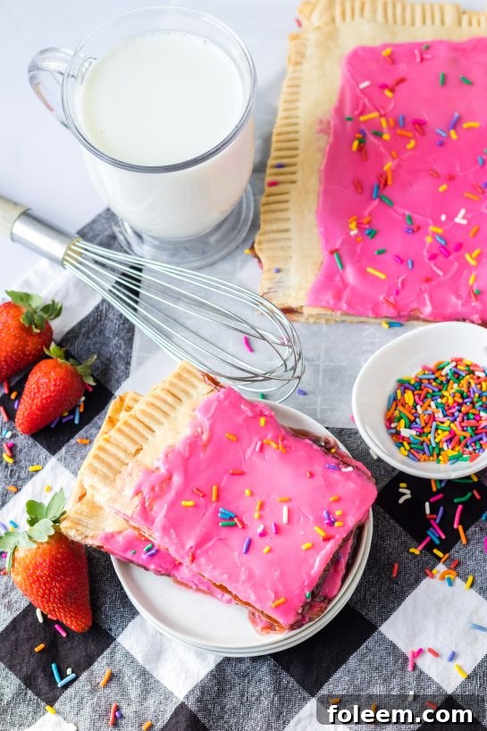 A close-up shot of a sliced Sheet Pan Strawberry Poptart, revealing the rich strawberry filling within the flaky pastry.