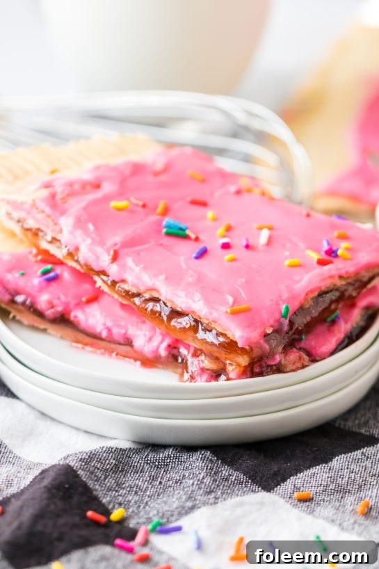 A delicious slice of Sheet Pan Strawberry Poptart, showcasing the flaky crust, real strawberry jam filling, and delicate icing with sprinkles.