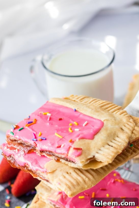 A top-down view of the beautifully iced and sprinkled Sheet Pan Strawberry Poptarts, ready for slicing and serving.