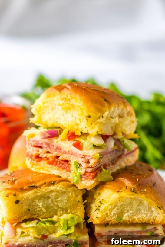 A close-up shot of an Italian Sub Slider, showcasing the melty cheese, meats, and fresh topping.