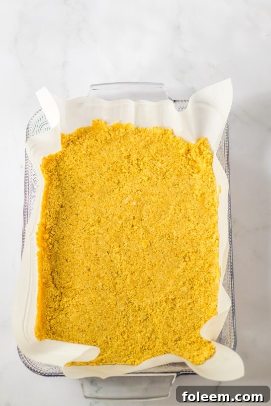 Pressing in the Oreo cookie crust needed to make the candy corn lush for fall dessert recipe