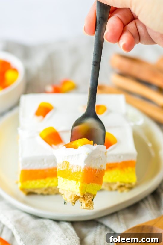 Close-up of a slice of the Candy Corn Lush recipe that is always a favorite at parties and is a make-ahead fall Halloween dessert that’ll make all ghouls go wild!