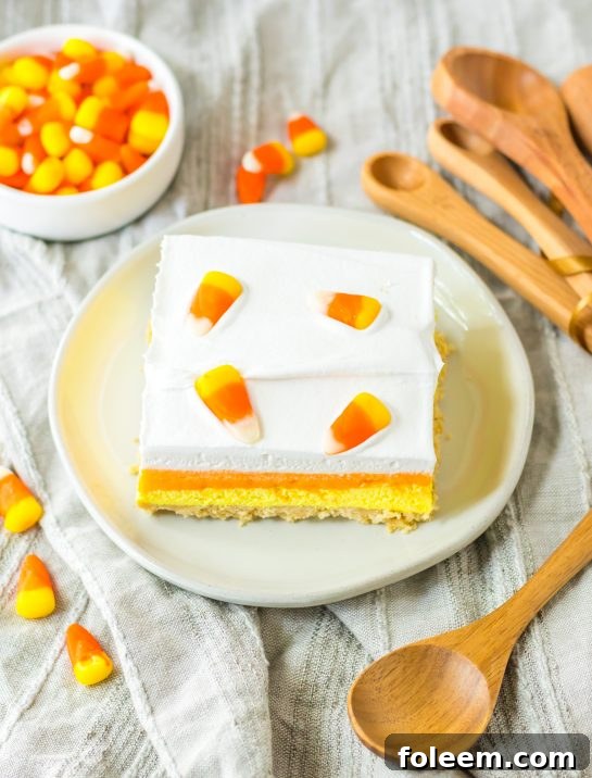 Overhead photo of a slice of the Candy Corn Lush recipe that is always a favorite at parties and is a make-ahead fall Halloween dessert that’ll make all ghouls go wild!