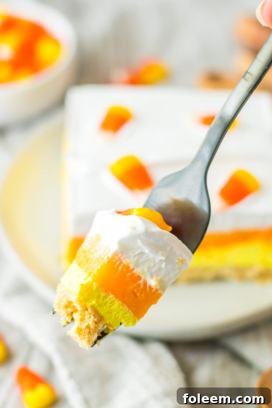 Close-up of a slice of the Candy Corn Lush recipe that is always a favorite at parties and is a make-ahead fall Halloween dessert.