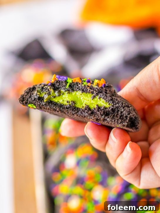 Stuffed Black Velvet Cookies are perfect for Halloween dessert recipe. Dark chocolate cookies are stuffed with a creamy, green cheesecake filling that is so delicious. Halloween sprinkles top off these spooky cookies that everyone will love.