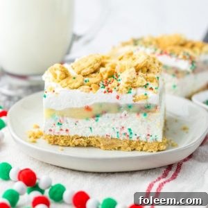 Christmas Cookie Lush, a festive no-bake holiday dessert featuring layers of vanilla cream cookies, creamy cheesecake, smooth pudding, whipped topping, and joyful sprinkles.