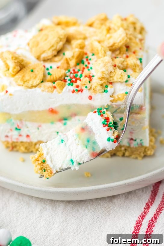Close-up of a perfectly sliced piece of Christmas Cookie Lush, revealing its stunning, colorful layers.