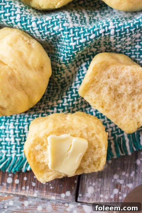 Golden-brown Mashed Potato Rolls, fresh and warm from the oven, cooling on a rack, perfect for Thanksgiving or Christmas dinners.