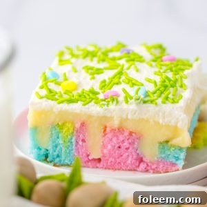 A close-up of the Easter Poke Cake, showing its vibrant layers, creamy pudding, and fluffy whipped cream, a perfect spring dessert.