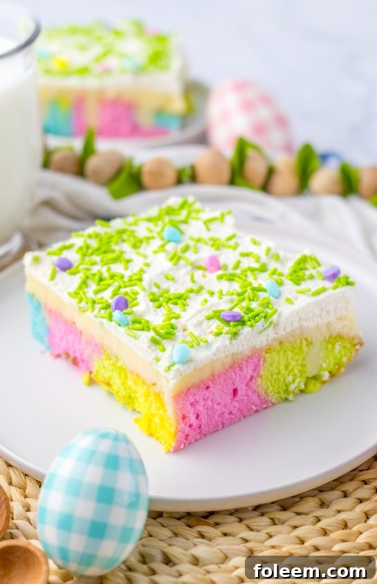 A beautifully decorated, simple holiday Easter Poke Cake with pastel swirls, white chocolate pudding, and a generous whipped cream topping.
