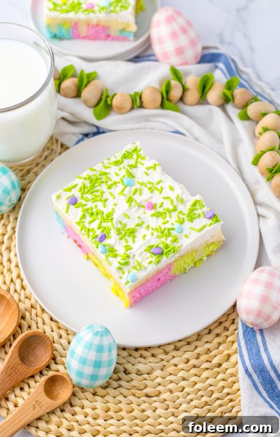 An inviting view of the Easy Easter Poke Cake, highlighting its colorful layers, creamy white chocolate pudding, and fluffy whipped cream.