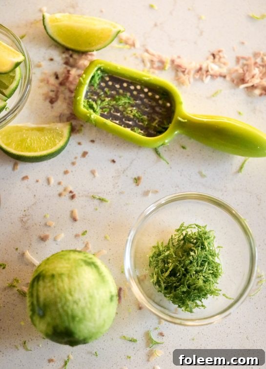 Capturing the essential step of zesting a fresh lime, a key component to infusing the Coconut Lime Frozen Margaritas recipe with its bright, aromatic, and tangy essence.
