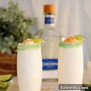 Coconut Lime Frozen Margaritas are a smooth, creamy, and easy to make frozen drink recipe!  Almost as easy as they are to sip on!  Creamy coconut blends with tequila and fresh lime topped with a crunchy toasted coconut rim.