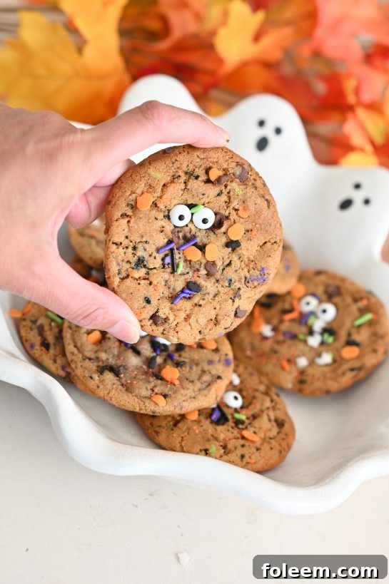 A plate of freshly baked Halloween Monster Chocolate Chip Cookies with candy eyes and colorful sprinkles, ready to be enjoyed.