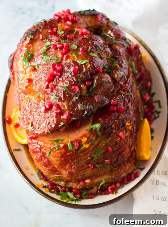 Overhead shot of the finished and beautifully glazed Christmas ham in a roasting pan, ready to be sliced.