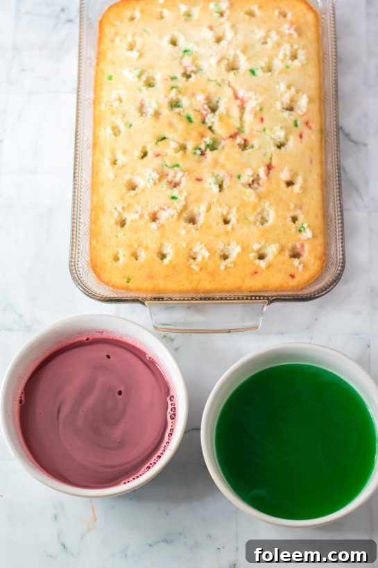 A hand using the back of a wooden spoon to poke holes into the baked white cake, preparing it for Jell-O.
