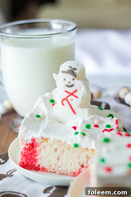 Another view of a delicious slice of Christmas Poke Cake, showcasing its colorful layers and festive topping.