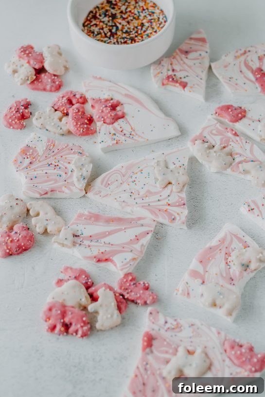 Close-up of freshly made Circus Cookie Bark showcasing its smooth white chocolate base, colorful circus animal cookies, and festive sprinkles.