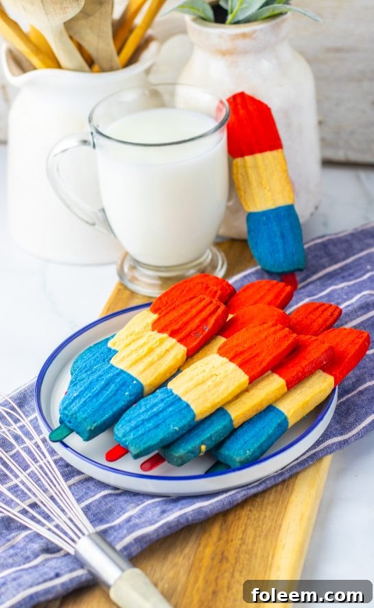 This recipe for Bomb Pop Cookies is not only so tasty but so cute for the 4th of July! These are the perfect dessert to bring for those red, white and blue holidays. Bursting with Sugar cookie flavors with hints of cherry flavoring in the red and blueberry flavoring in the blue, using Jello! These were so fun to make and were a huge hit for everybody involved!