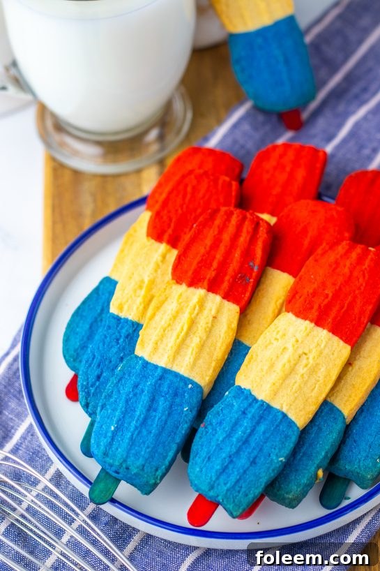 This recipe for Bomb Pop Cookies is not only so tasty but so cute for the 4th of July! These are the perfect dessert to bring for those red, white and blue holidays. Bursting with Sugar cookie flavors with hints of cherry flavoring in the red and blueberry flavoring in the blue, using Jello! These were so fun to make and were a huge hit for your summer picnic!