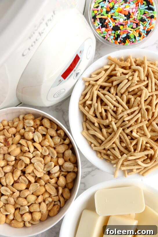 Ingredients for White Chocolate Halloween Crock Pot Candy: white chocolate bark, chow mein noodles, dry roasted peanuts, and Halloween sprinkles.