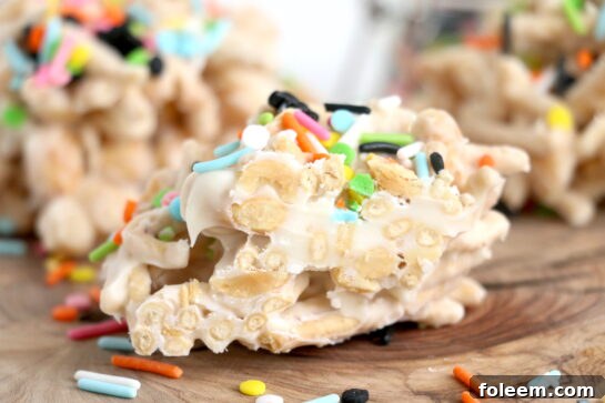 Close-up of individual White Chocolate Halloween Crock Pot Candy clusters with colorful sprinkles.