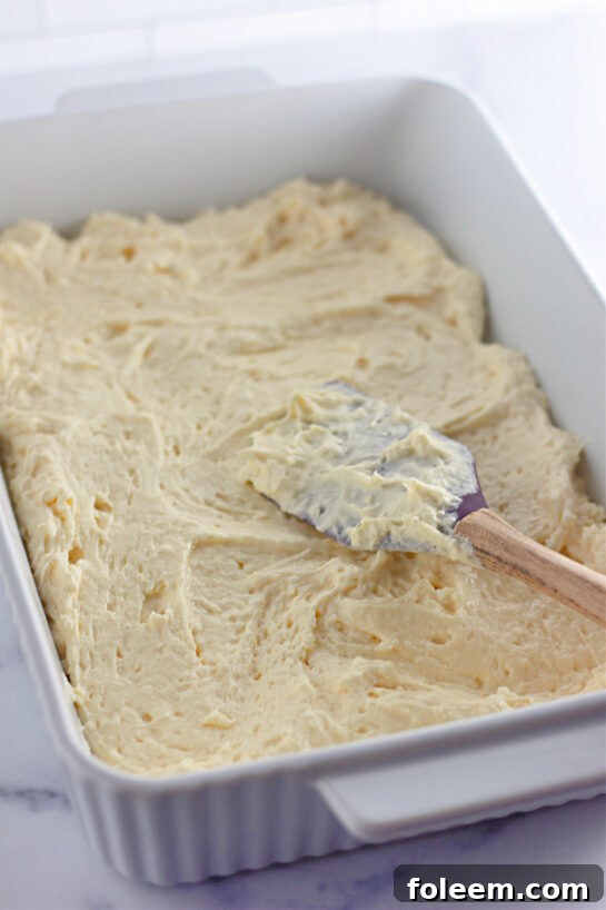 Spreading the cake batter into the pan to get ready to bake the Honey Bun Cake recipe
