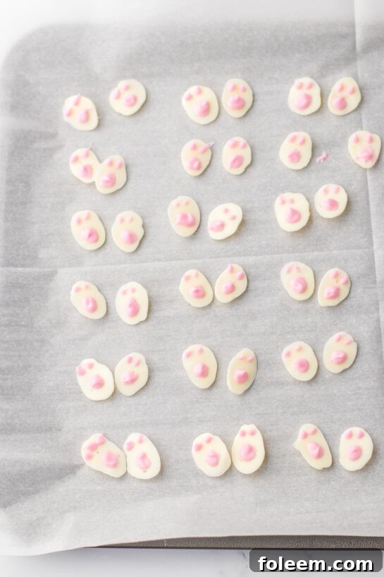 Attaching the delicate white chocolate bunny feet to the truffles for an extra touch of charm.