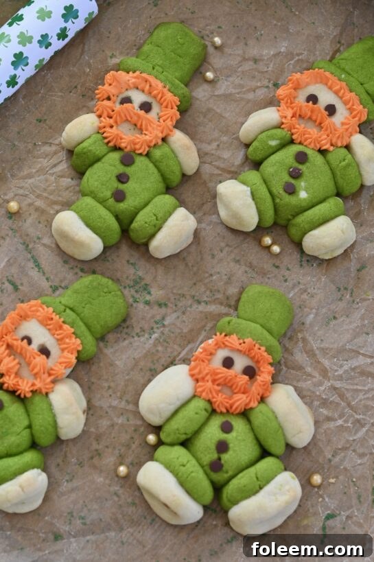 Charming Lucky Leprechaun Cookies with green and white sugar cookie dough, chocolate chip buttons, and orange frosting beards for St. Patrick's Day