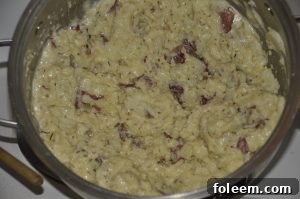 Close-up of creamy garlic smashed potatoes garnished with fresh rosemary.