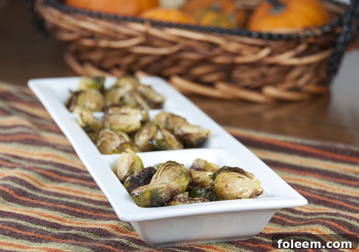A vibrant close-up of roasted Brussels sprouts, perfectly golden-brown and crispy, with a hint of char.