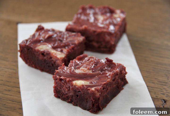 Rich Red Velvet Cheesecake Brownies swirled with creamy cheesecake, perfect for Valentine's Day or Christmas desserts.