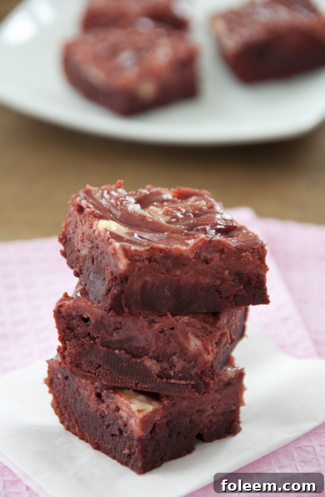 Close-up of baked Red Velvet Cheesecake Swirl Brownies, showcasing the vibrant red and white pattern.