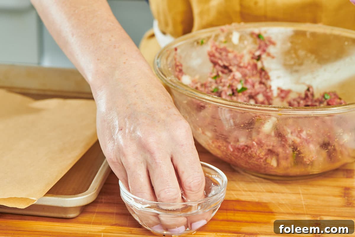 Woman dipping fingers into small bowl of water.