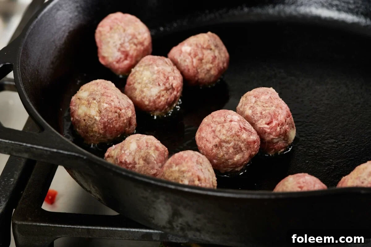 Cooking meatballs in skillet.