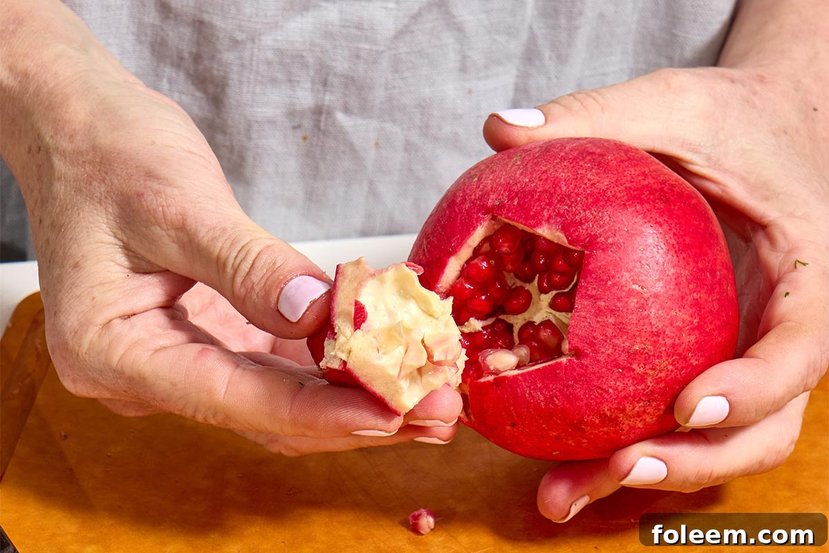 Woman pulling blossom from pomegranate.