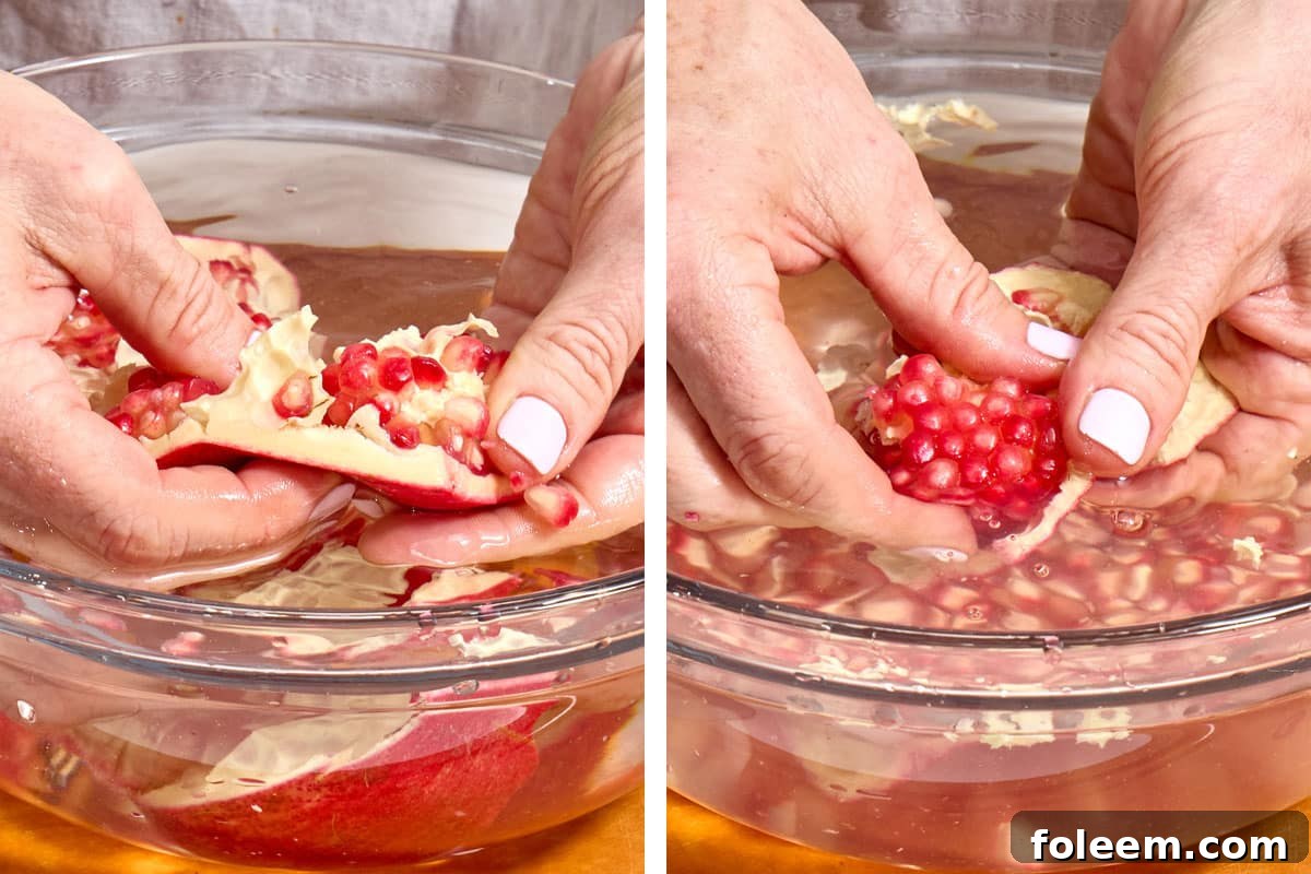 Woman removing pomegranate arils from fruit over bowl of water.