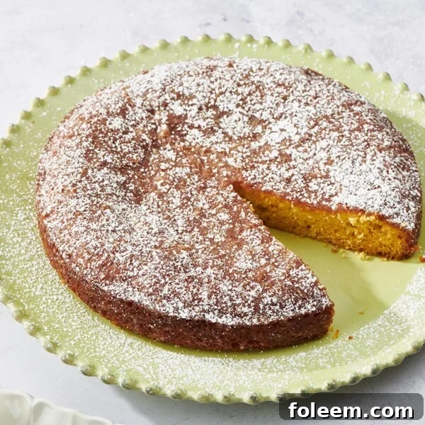 Orange Cake missing a slice on a green plate.