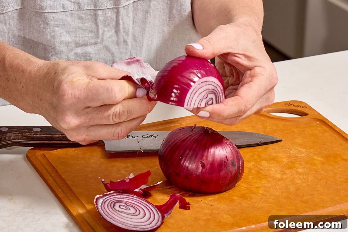 Peeling skin off red onion.