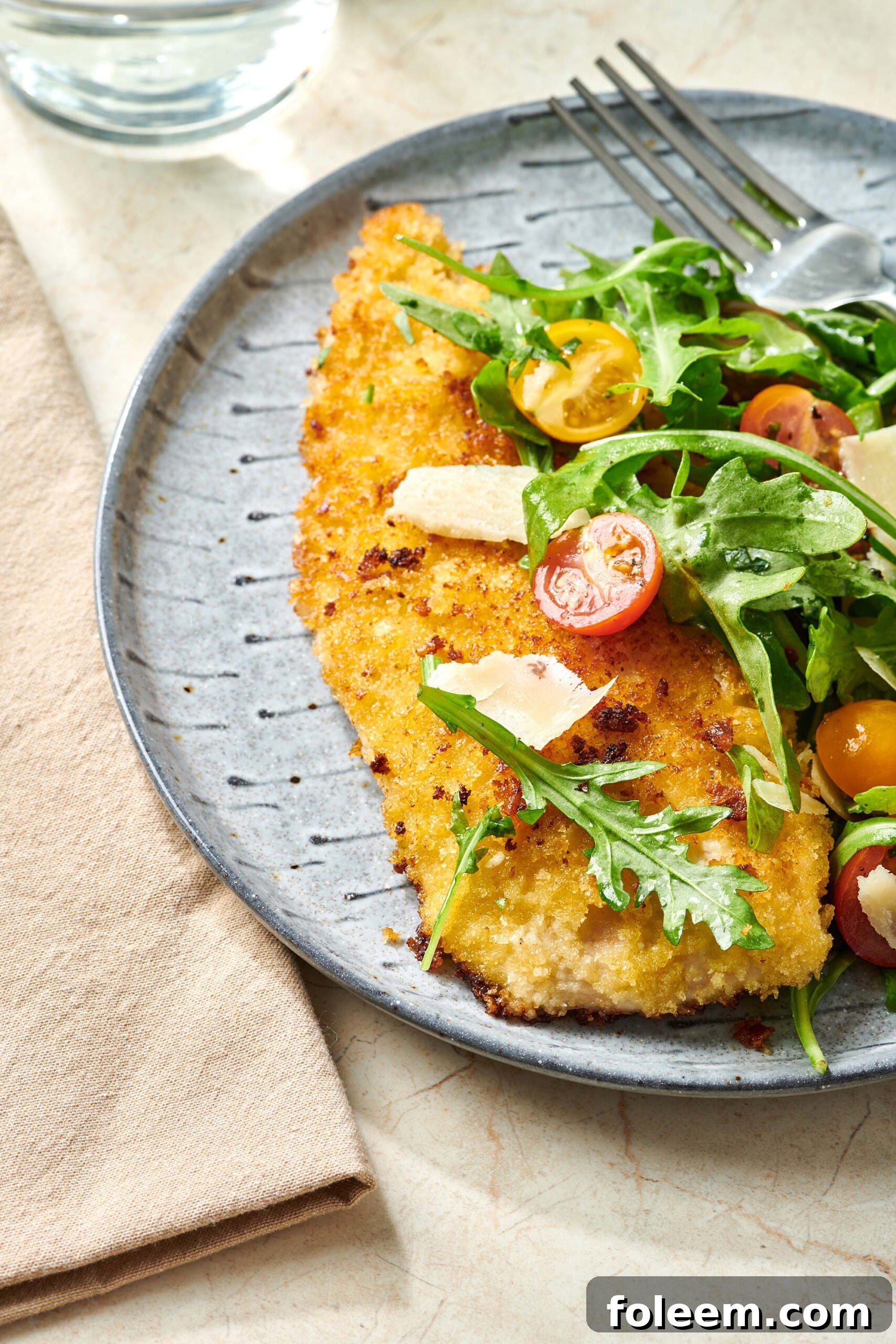 Chicken Milanese on plate with salad.