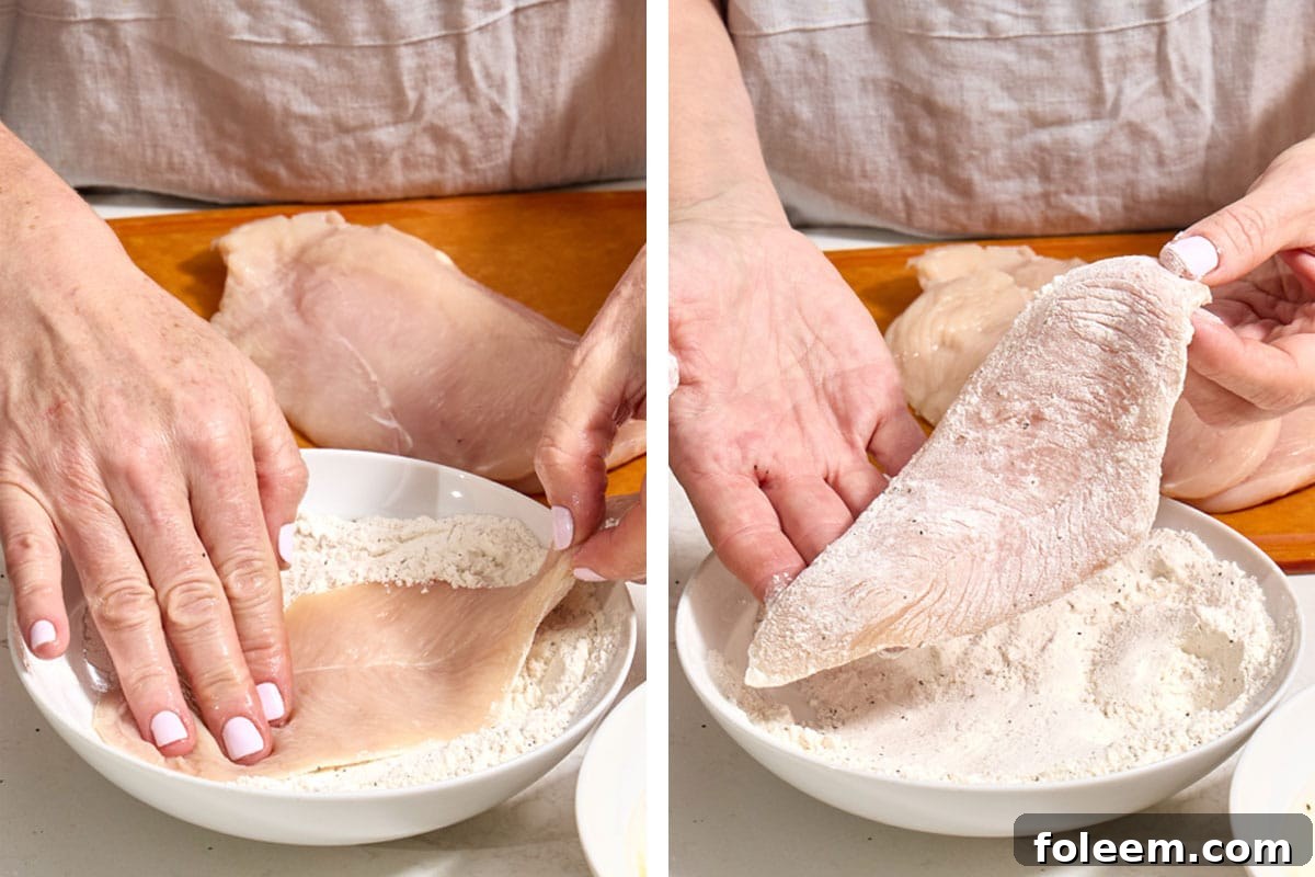 Woman dredging chicken cutlet in seasoned flour.
