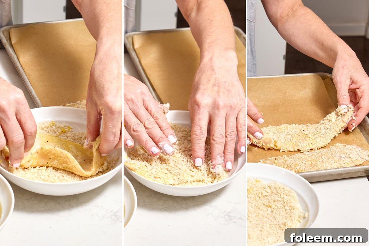 Woman breading chicken cutlet with panko breadcrumbs.