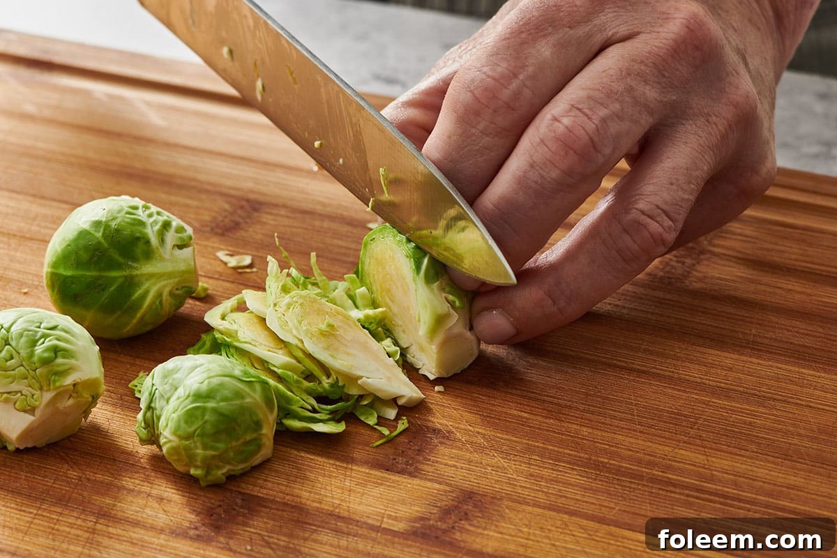 Slicing Brussels sprout into thin shreds with knife.