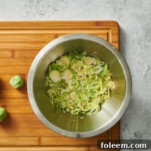 Shredded and whole Brussels sprouts in bowl and on cutting board.