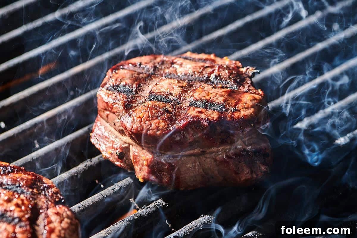 Cooked filet mignon steaks with cross-hatch grill marks on cutting board.