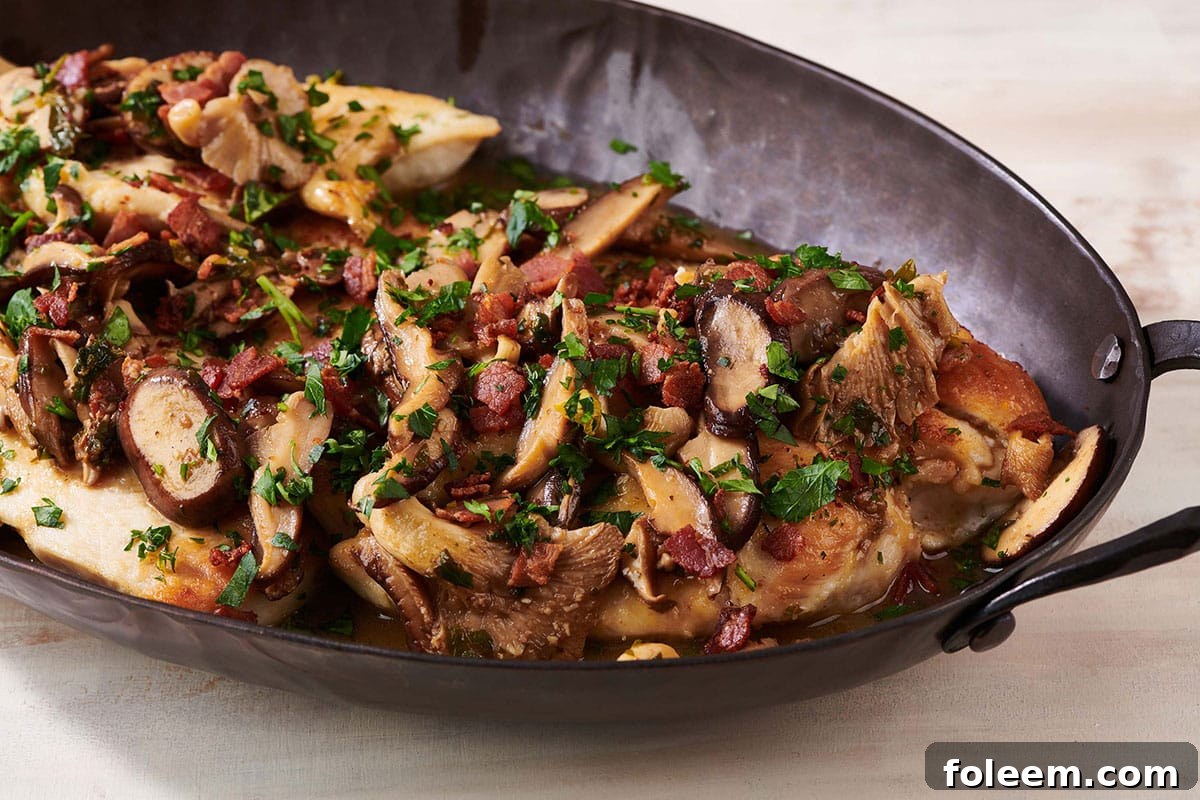 Black serving platter of Chicken Marsala.