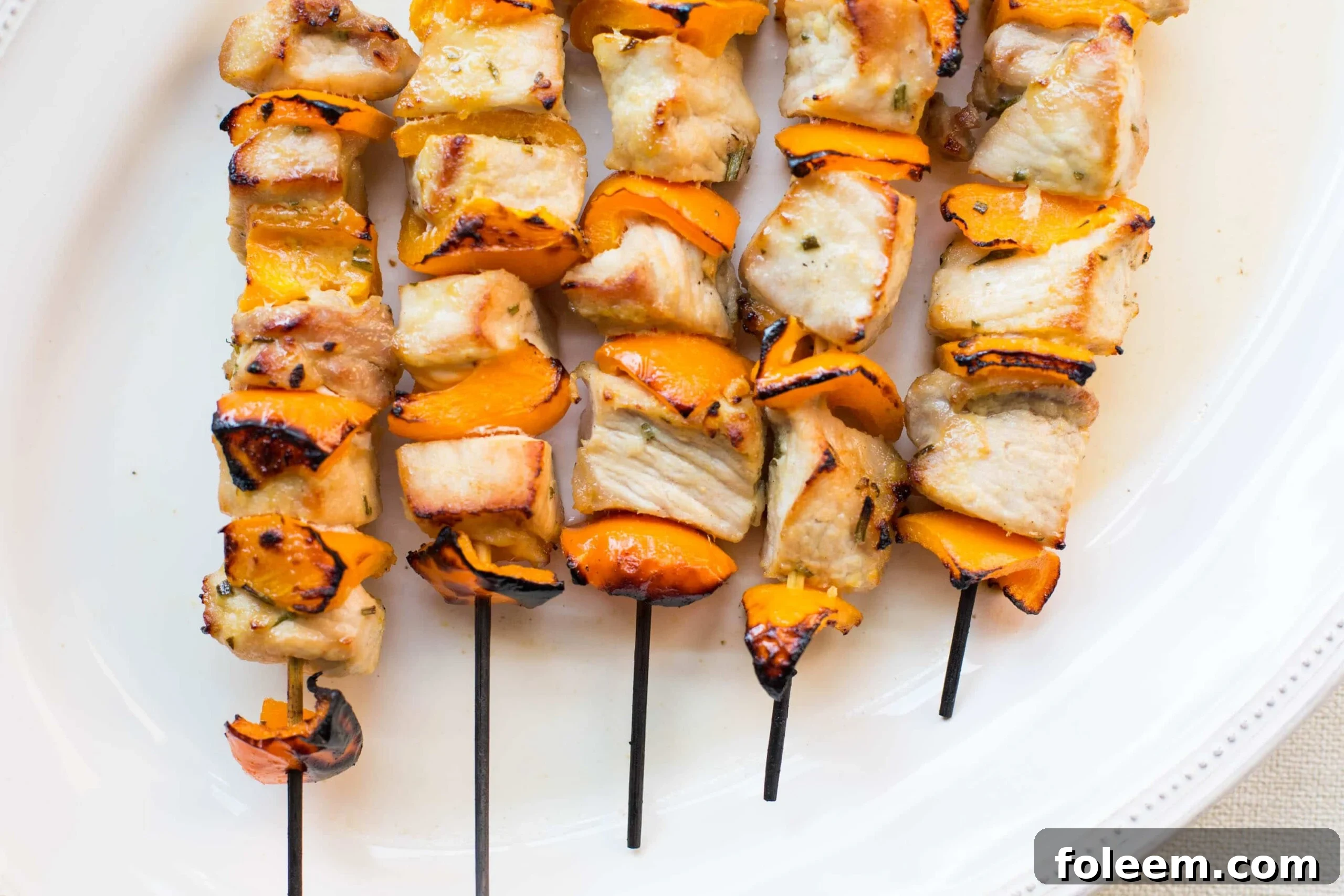 Skewered Mustard and Maple Pork Kebabs on white plate.